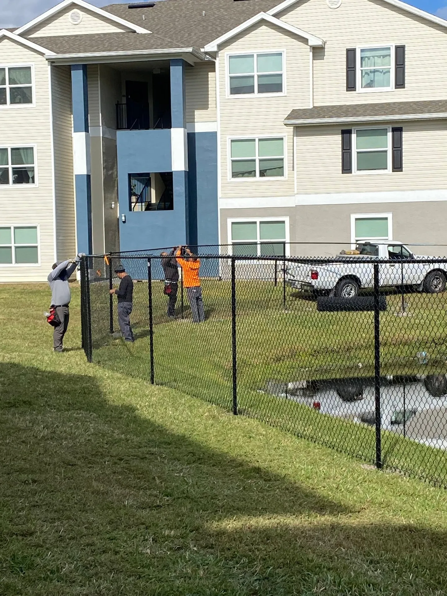 Dark chain-link fence beside a pond.