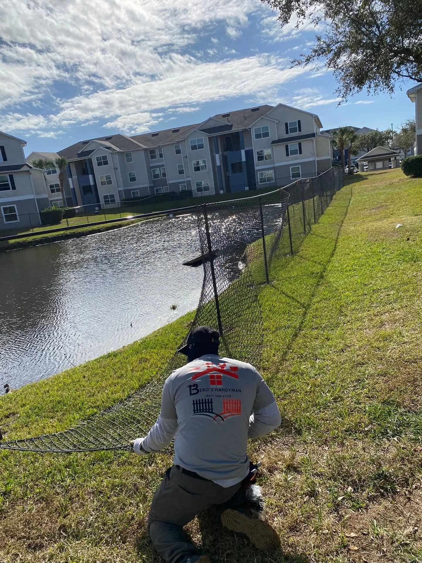 Dark chain-link fence beside a pond.