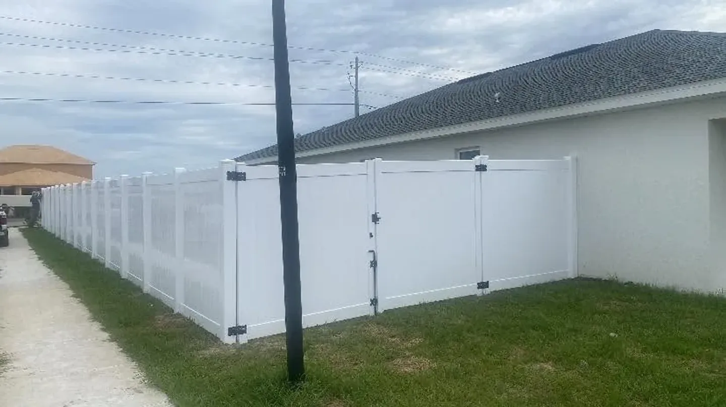 White vinyl privacy fence with a gate.