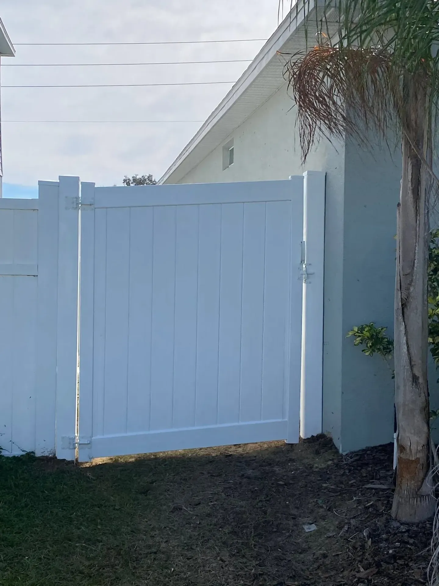 White vinyl side gate beside a home.