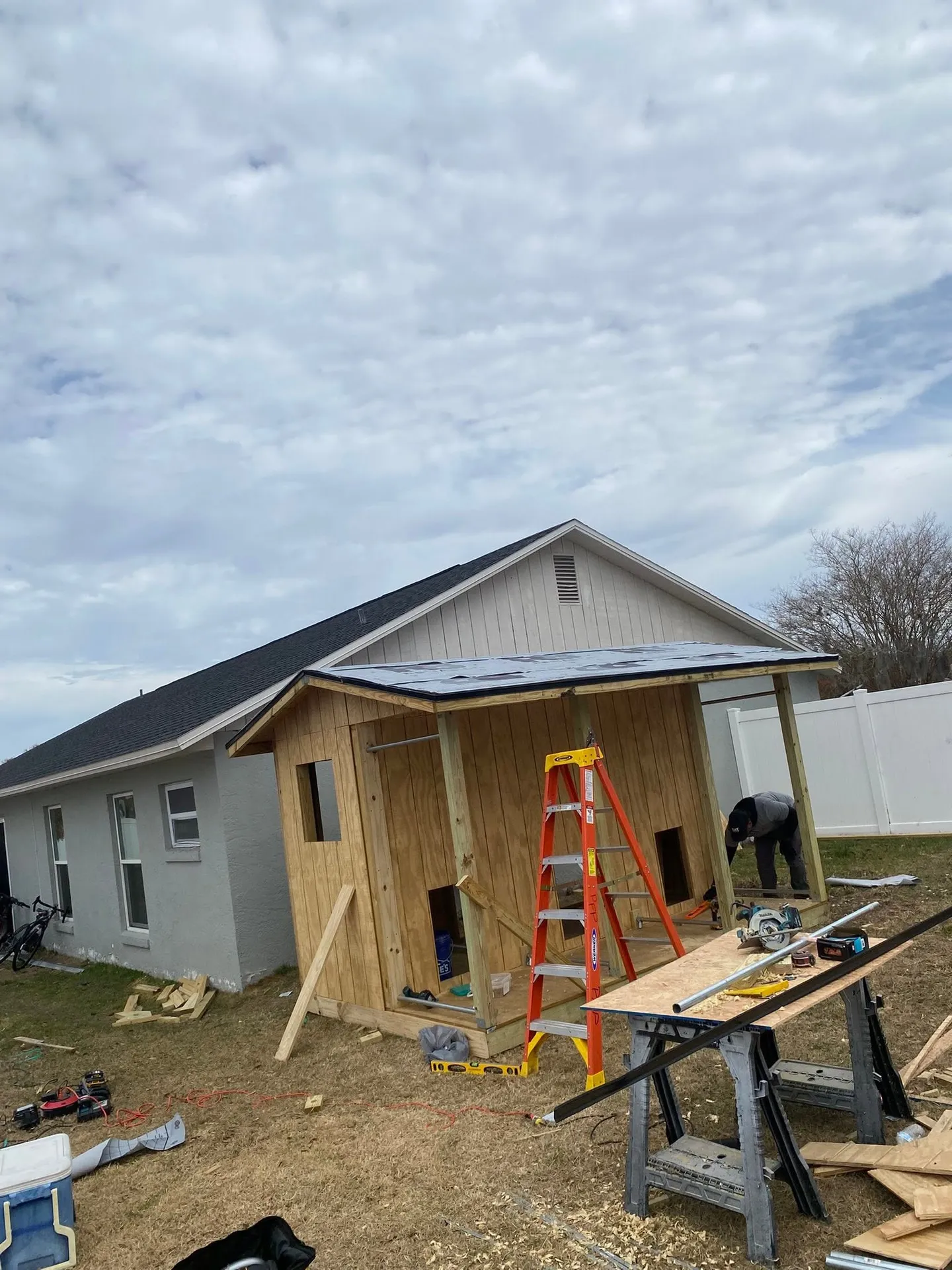 Wood utility shed during construction and after completion.