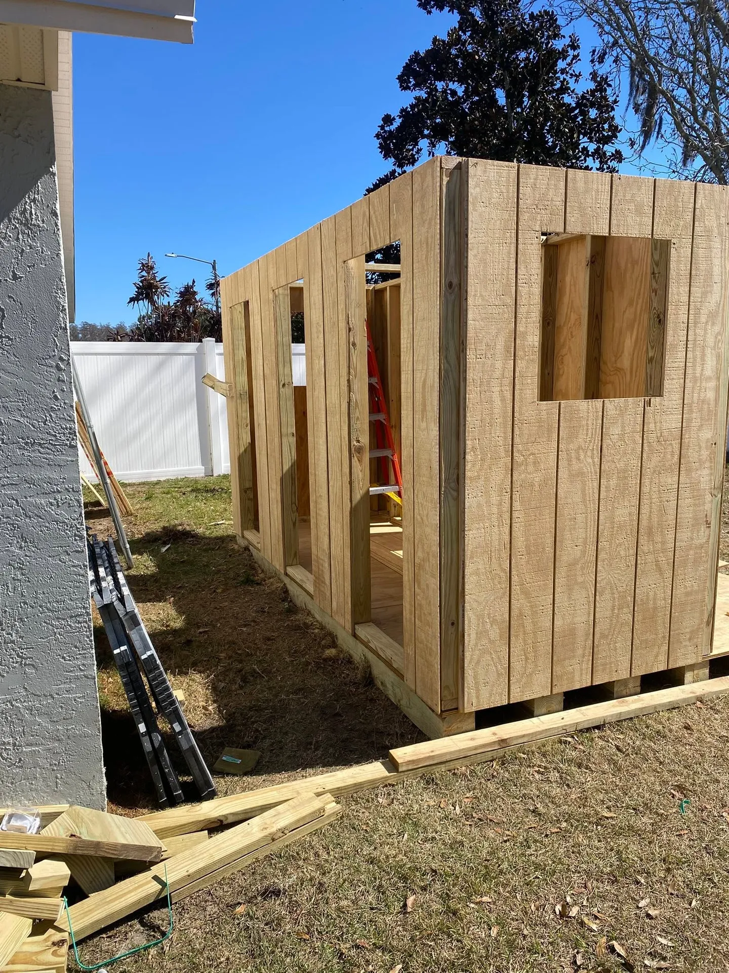 Wood utility shed during construction and after completion.