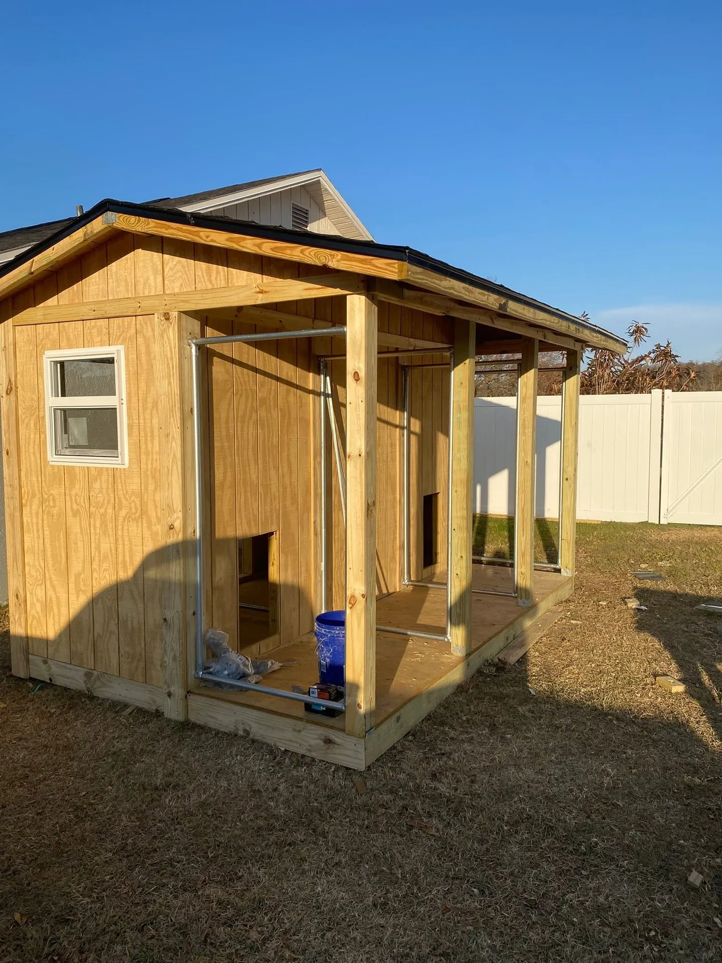 Wood utility shed during construction and after completion.