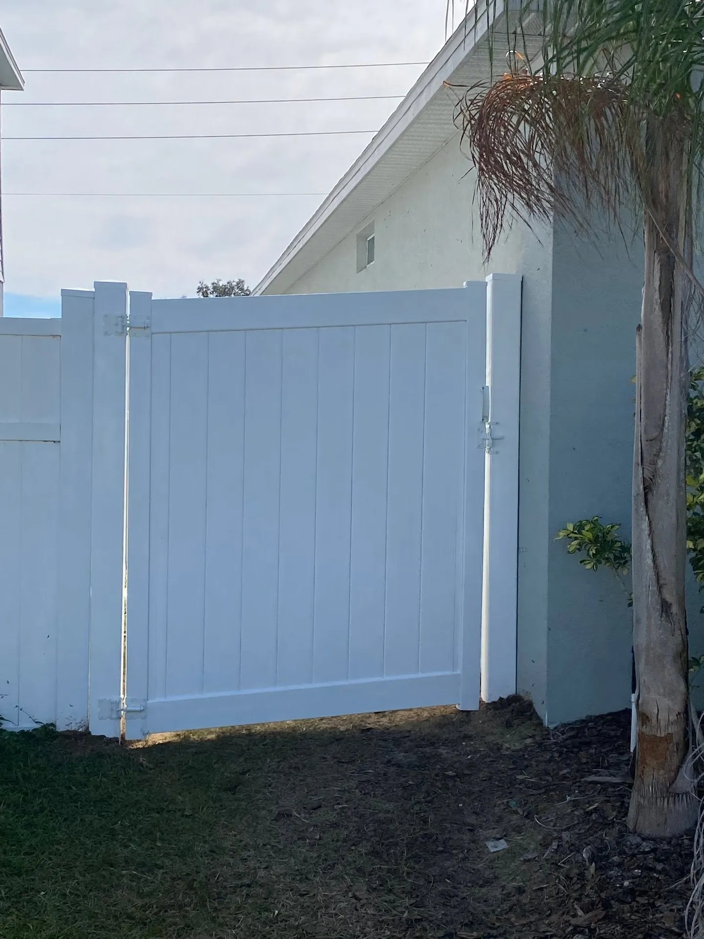 White vinyl side gate beside a home.